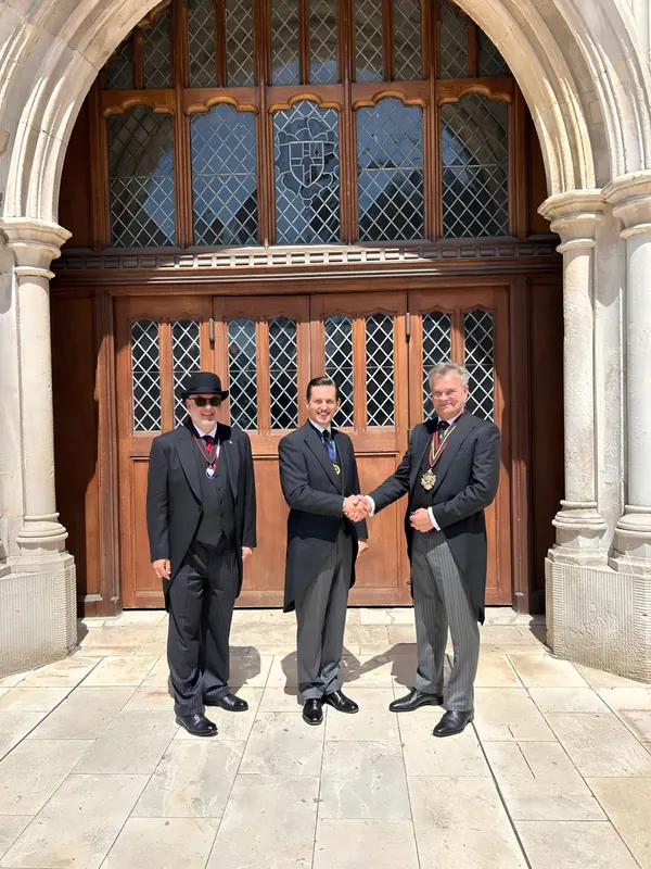 Liam Randall (centre) shaking hands with the Master, Tony Miller MBE (right), on his election as Ale Conner at Common Hall, 24 June 2026; the Coopers' Company Clerk stands at left.