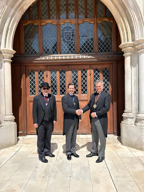 Liam Randall (centre) shaking hands with the Master, Tony Miller MBE (right), on his election as Ale Conner at Common Hall, 24 June 2026; the Coopers' Company Clerk stands at left.
