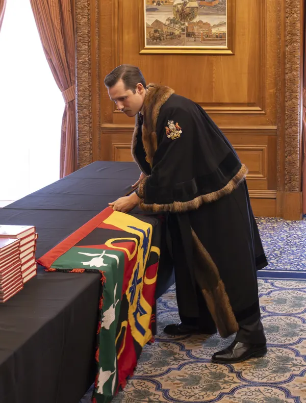 Liam Randall in the livery gown of the Worshipful Company of Coopers, handling the Company's colours.